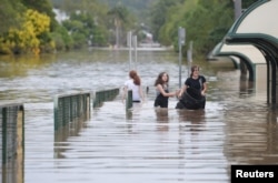 Locals walk through a flooded street in the northern New South Wales town of Lismore, Australia, April 1, 2017, after heavy rains associated with Cyclone Debbie swelled rivers to record heights across the region.