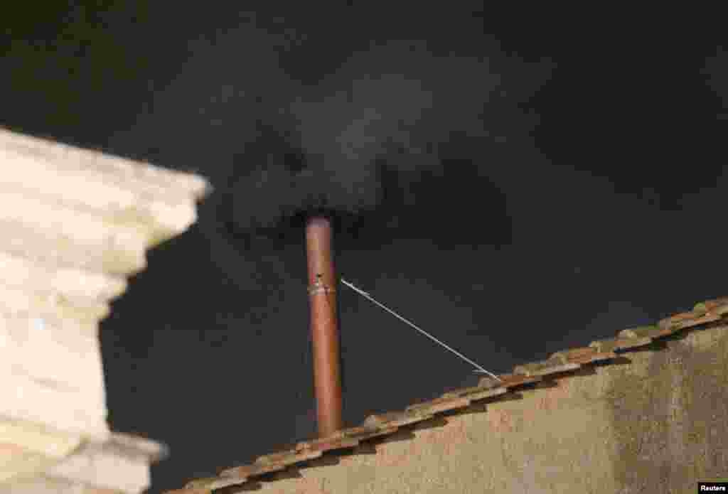 La fum&eacute;e noire sortant de la ch&eacute;min&eacute;e au dessus la Chappelle sixtine au Vatican, 12 mars, 2013. 