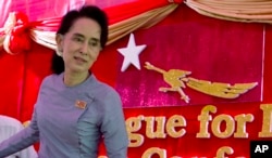 ຜູ້ນຳຝ່າຍຄ້ານ ທ່ານນາງ Aung San Suu Kyi ກຳລັງອອກຈາກ ການຖະແຫລງນ່າວ ທ່ບ້ານພັກຂອງທ່ານ