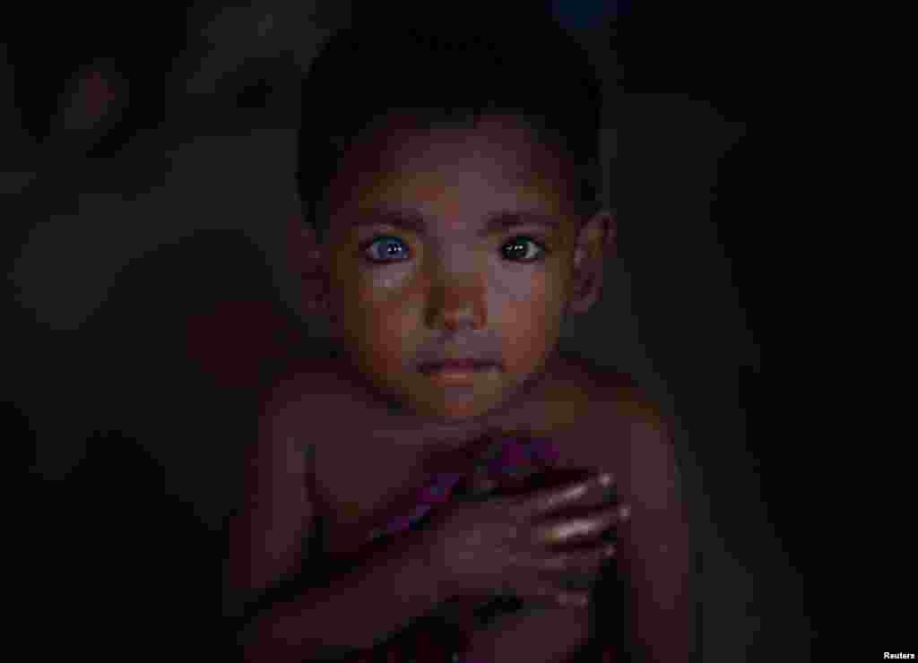 두 달 전 미얀마에서 방글라데시 콕스바자르의 쿠투팔롱난민촌으로 탈출한 4살 로힝야족 소년이 어린이보호소에서 다른 어린이들의 노래를 듣고 있다.&nbsp;
