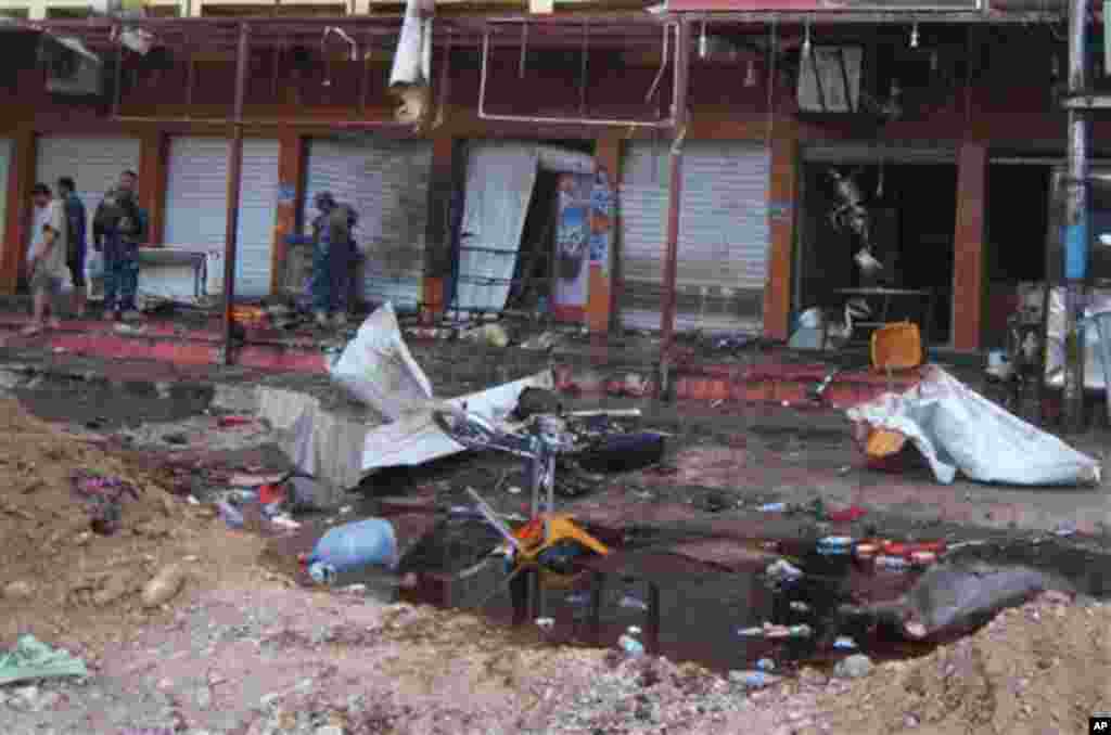 Security forces inspect scene of suicide bombing at a coffee shop, Kirkuk, Iraq, July 13, 2013.