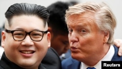 Howard X, một công dân Úc gốc Hoa chuyên đóng giả ông Kim Jong Un (trái), và ông Russell White, đóng giả TT Mỹ Donald Trump, chụp ảnh ở Hà Nội, ngày 22/2/2019. (REUTERS/Jorge Silva) 
