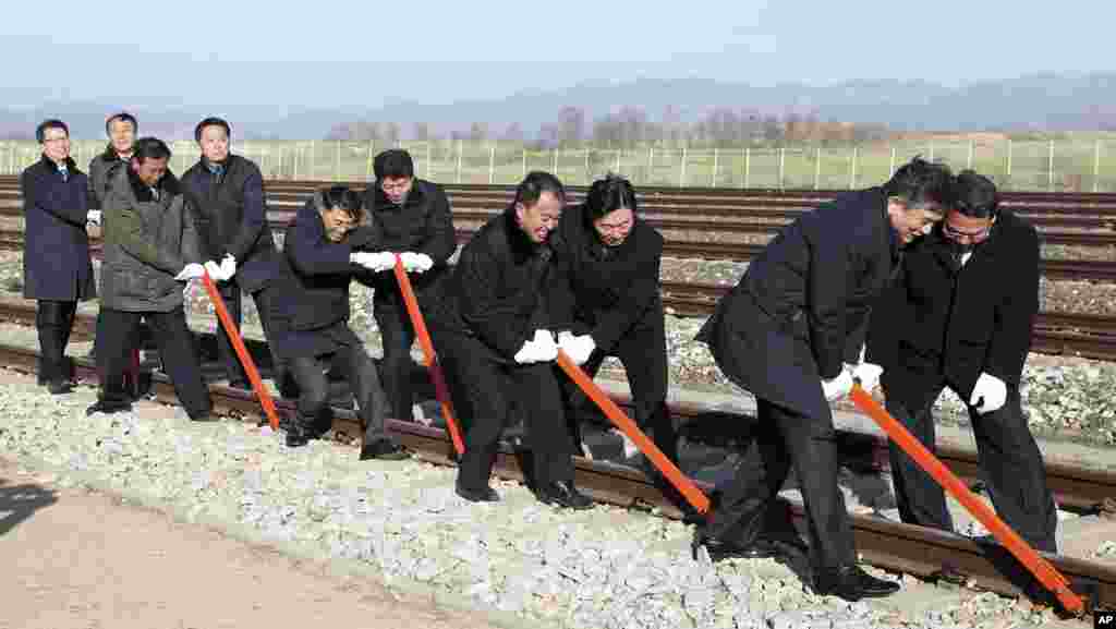 South and North Korean government officials connect northern and southern railroad tracks during a groundbreaking ceremony at Panmun Station in Kaesong, North Korea.