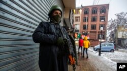 FILE -Indian paramilitary soldiers stand guard in Srinagar, Kashmir, Jan. 8, 2022. The Committee to Protect Journalists asked Indian authorities to release journalist Sajad Gul in Kashmir, days after police arrested him for uploading a video clip of a protest against Indian rule.
