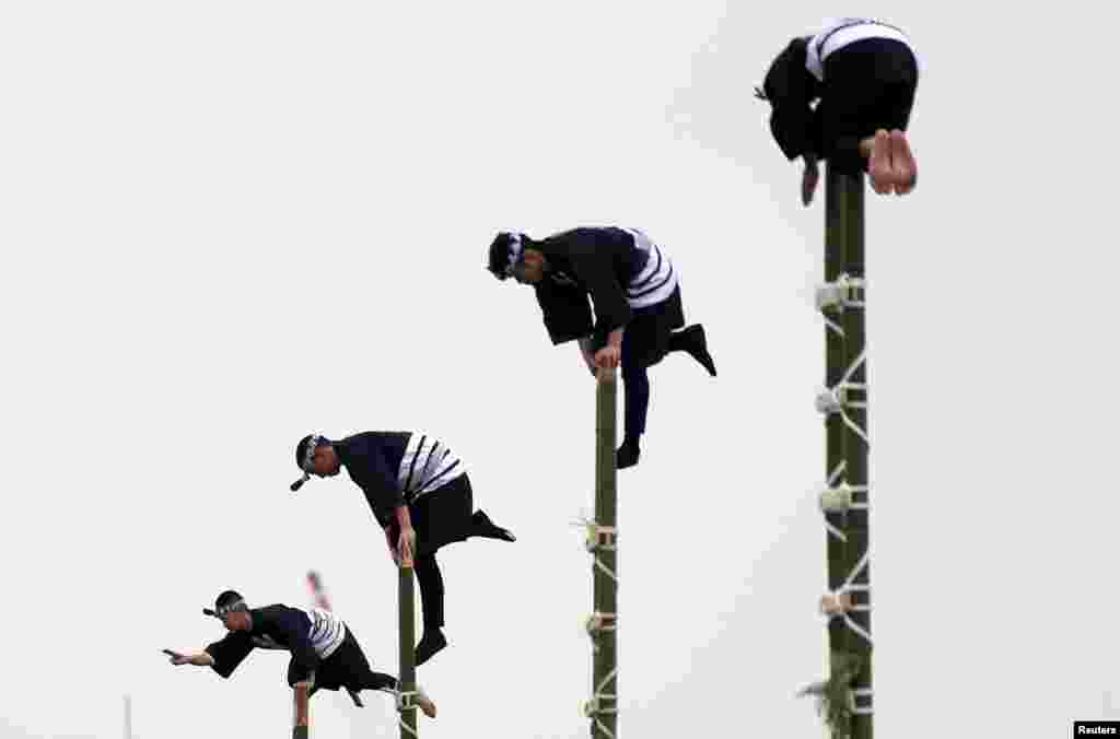 Members of the Edo Firemanship Preservation Association display their balancing skills atop bamboo ladders during a New Year demonstration by the fire brigade in Tokyo, Japan.