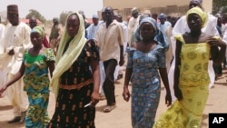 Four female students of government secondary school Chibok, who were abducted by gunmen and reunited with their families walk in Chibok, Nigeria, April 21, 2014.