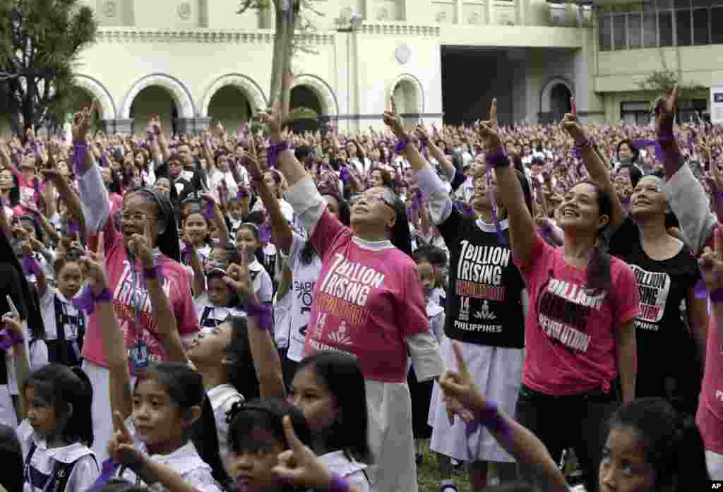 More than 3,000 students, teachers and nuns from the Catholic-run St. Scholastica&#39;s College, wear purple ribbons and dance to take part in the global campaign to end violence against women and girls dubbed One Billion Rising, in Manila, Philippines.