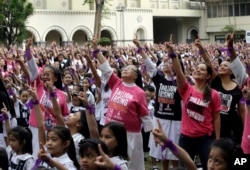 FILE - More than 3,000 students, teachers and nuns from the Catholic-run St. Scholastica's College in Manila, dance to take part in the global campaign to end violence against women and girls dubbed One Billion Rising, in Manila, Philippines, Feb. 13, 2015.