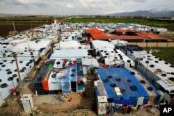 Syrian refugee children play outside their family tents after heavy rain at a refugee camp in the town of Bar Elias, Bekaa Valley, Lebanon, Jan. 10, 2019.