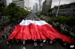 Supporters of Indonesian presidential candidate Prabowo Subianto display a large national Red-White flag during a protest in Jakarta, Indonesia, May 22, 2019.