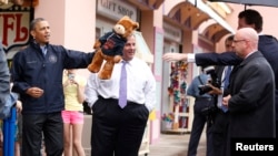 Barack Obama , brandissant un ours en peluche gagné mardi au bord d'une plage du New Jersey 