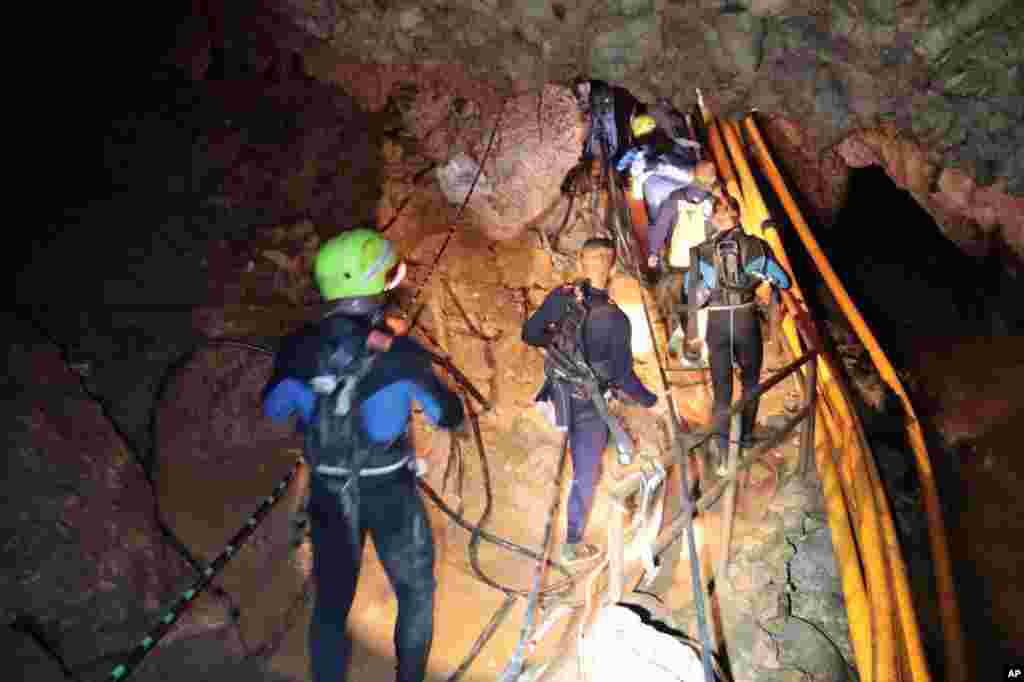 In this undated photo released by Royal Thai Navy, July 7, 2018, Thai rescue team members walk inside a cave in Mae Sai, Chiang Rai province, northern Thailand.