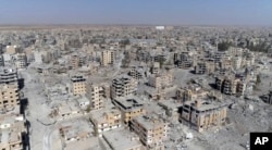 Una imagen de Raqqa tomada de un video de drone muestra decenas de edificios dañados en Raqqa, Siria, dos días después que las Fuerzas Democráticas Sirias dijeran que las operaciones militares para desalojar al Estado Islámico habían terminado. Oct. 19, 2017.