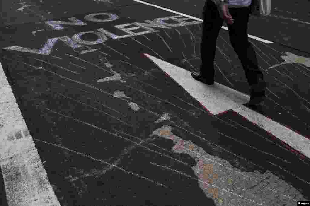 一名抗议者通过旺角购物区主要街道; 地上写有：”非暴力”的标语