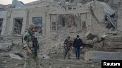 Afghan security forces and NATO troops investigate at the site of an explosion near the German consulate office in Mazar-i-Sharif, Afghanistan, Nov. 11, 2016.