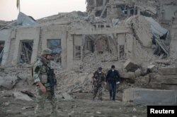 Afghan security forces and NATO troops investigate at the site of explosion near the German consulate office in Mazar-i-Sharif, Afghanistan, Nov. 11, 2016.