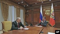Russia's President Dmitry Medvedev (R) and Prime Minister Vladimir Putin speak before a meeting with Security Council members at the Gorki presidential residence outside Moscow, March 2, 2012. 