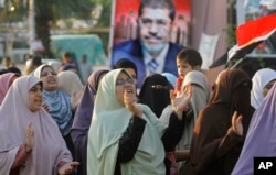 Supporters of Egypt's ousted president, Mohamed Morsi, shout slogans at a park in front of Cairo University, July 18, 2013.