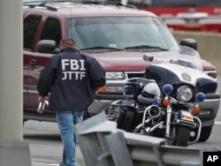 FILE - A law enforcement official wearing an FBI Joint Terrorism Task Force jacket works near the Pentagon, June 17, 2011, in Arlington, Va.