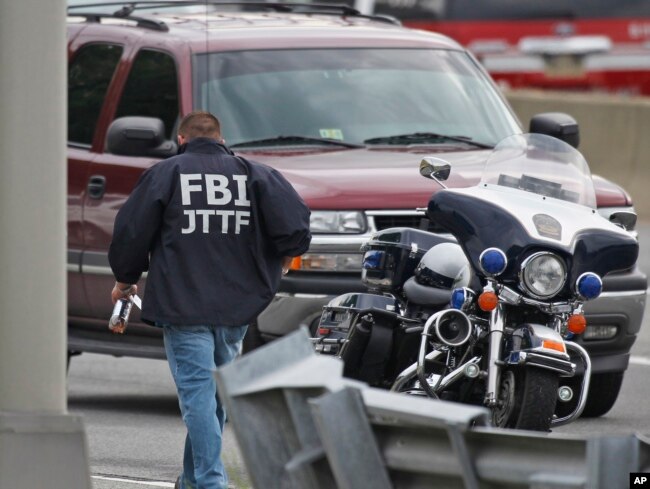 FILE - A law enforcement official wearing an FBI Joint Terrorism Task Force jacket works near the Pentagon, June 17, 2011, in Arlington, Va.