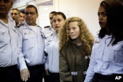 FILE - Ahed Tamimi, from the West Bank village of Nabi Saleh, is brought to a courtroom inside Ofer military prison near Jerusalem, Dec. 28, 2017.