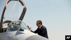 Serbian President Aleksandar Vucic speaks with a pilot of MiG-29 jet fighter on the tarmac at Batajnica, military airport near Belgrade, Serbia, Aug. 21, 2018. 