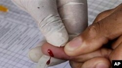 A patient undergoes a pin prick blood test inside a mobile health care clinic parked in downtown Johannesburg. (file)