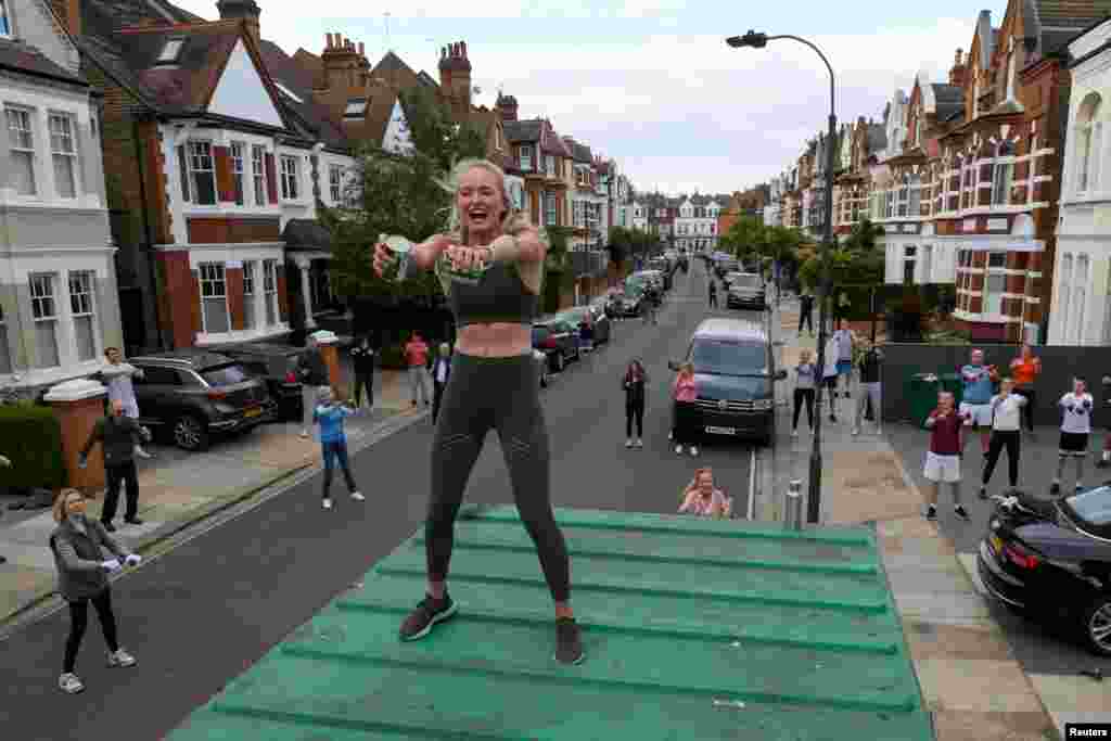 Personal trainer Flo Dowler leads the residents of Napier Avenue in a workout in Fulham, West London, May 11, 2020.