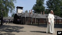 Le pape François traverse l’entrée de l'ancien camp d'extermination nazi allemand d'Auschwitz à Oswiecim, Pologne, 29 juillet 2016.