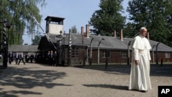 Pope Francis walks through the gate of the former Nazi German death camp of Auschwitz in Oswiecim, Poland, July 29, 2016.