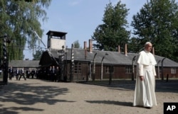 FILE - Pope Francis walks through the gate of the former Nazi German death camp of Auschwitz in Oswiecim, Poland, Friday, July 29, 2016.