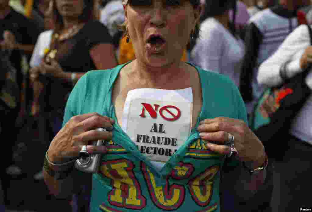 A supporter of opposition leader Henrique Capriles wears a sign that reads, &quot;No election fraud,&quot; while demonstrating for a recount of the votes in Sunday&#39;s election, in Caracas, April 15, 2013.&nbsp;