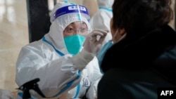 中國哈爾濱一位醫療人員在進行新冠檢測採樣 （法新社 2021年1月14日）