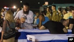 Relatives mourn over the coffins of people killed in a bombing in Bulgaria as the remains arrived back at an airport in Tel Aviv, Israel, July 20, 2012. 