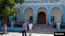 FILE - People walk outside Somalia's central Bank in Hamarwayne district, south of capital Mogadishu, May 16, 2013.