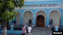 People walk outside Somalia's central Bank in Hamarwayne district, south of capital Mogadishu, May 16, 2013.