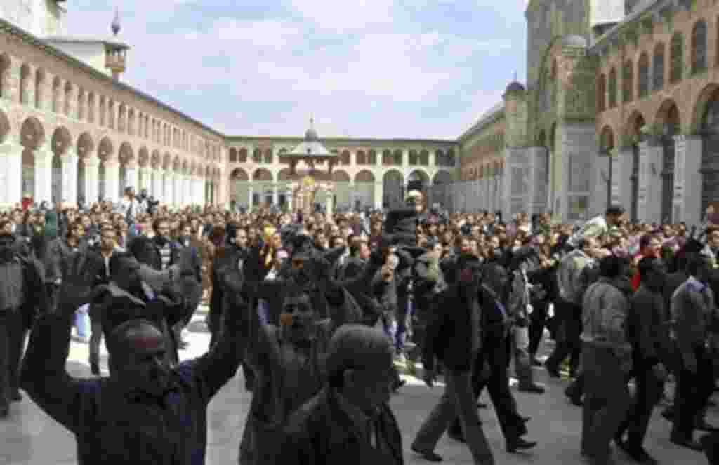 Syrian protesters shout slogans outside the Omayyad Mosque after Friday prayers in Damascus, March 25, 2011