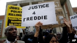 FILE - Protestors stand outside of the Baltimore Police Department's Western District police station during a march and vigil for Freddie Gray, April 21, 2015.
