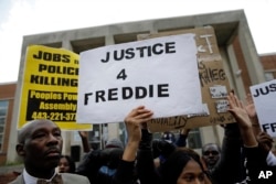 FILE - Protestors stand outside of the Baltimore Police Department's Western District police station during a march and vigil for Freddie Gray, April 21, 2015