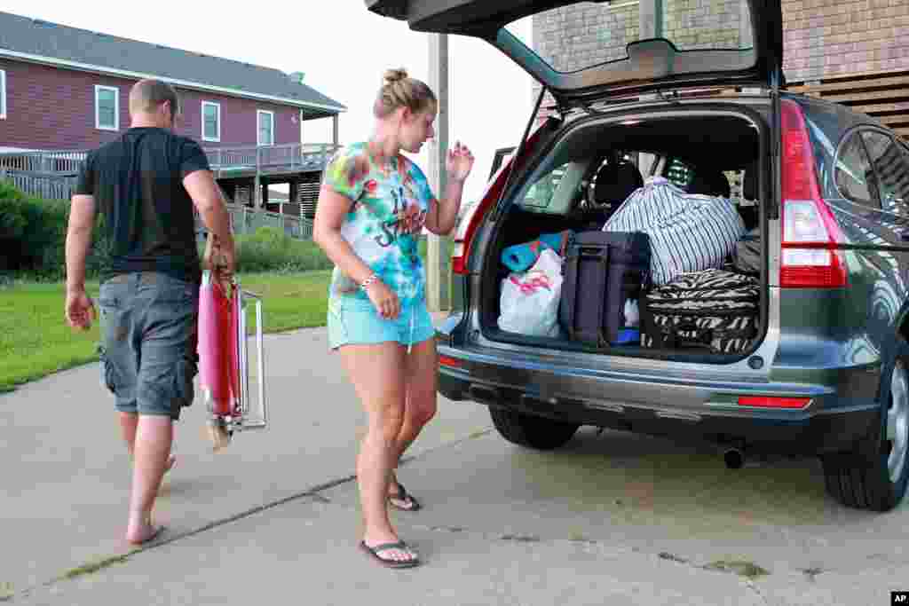 Nicole Specht and Ryan Witman pack their Honda CRV before heading back home to Lancaster, Pennsylvania because of the mandatory evacuation, in Rodanthe, N.C., July 3, 2014.