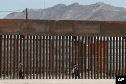 멕시코 시우다드후아레스에 있는 미국 국경 장벽을 따라 이주자들이 걷고 있다. (자료사진)