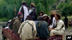 FILE - Pakistani Taliban patrol in their stronghold of Shawal in Pakistani tribal region of South Waziristan, Aug. 5, 2012.