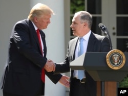 FILE - In this June 1, 2017 photo, President Donald Trump shakes hands with EPA Administrator Scott Pruitt after speaking about the Paris climate change accord in the Rose Garden in Washington.