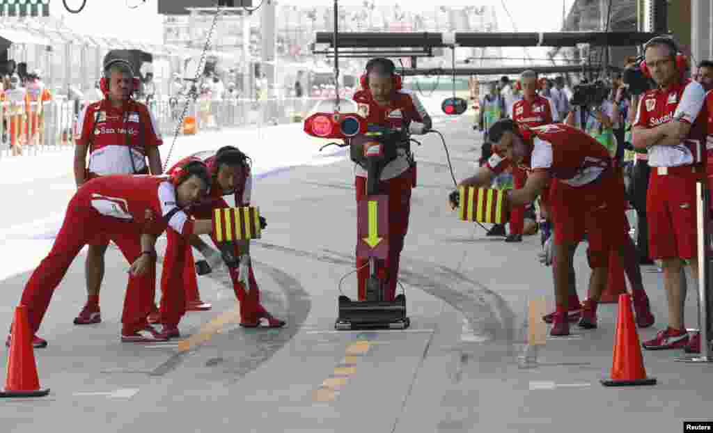 Các nhân viên bảo trì chờ tay đua Felipe Massa người Brazil của Ferrari Formula One trong phiên tập luyện thứ ba Giải Korean F1 tại Vòng đua Quốc tế Triều Tiên ở Yeongam, Nam Triều Tiên.
