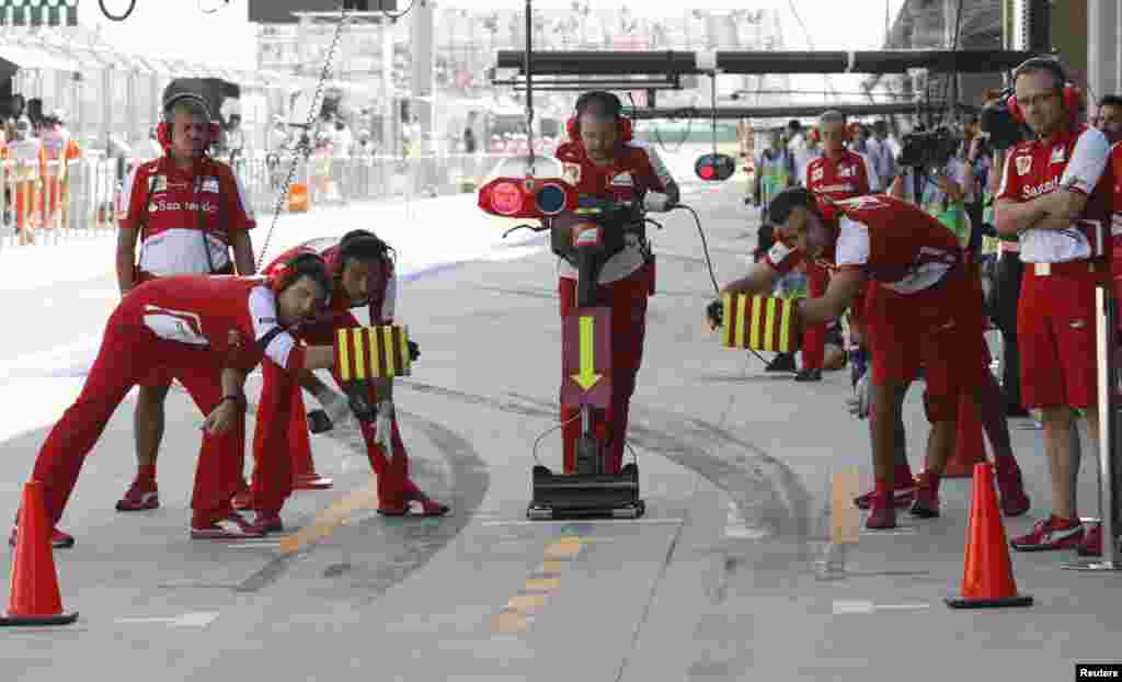 Pit crew wait for Ferrari Formula One driver Felipe Massa of Brazil during the third practice session of the Korean F1 Grand Prix at the Korea International Circuit in Yeongam, South Korea.