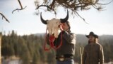 Mo (actor Mo Brings Plenty) raises a bison skull in a vision quest ceremony for Kayce Dutton (Luke Grimes) in Season 4, Episode 9 of Paramount+ "Yellowstone."