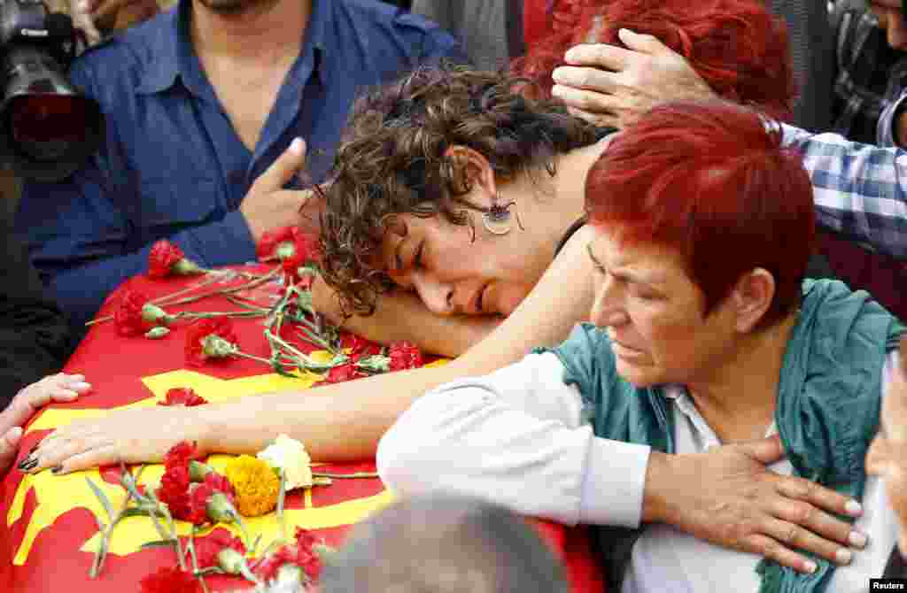 Family members of Korkmaz Tedik, a victim of bomb blasts, mourn over his coffin during a funeral ceremony in Ankara, Turkey. Thousands of people, many chanting anti-government slogans, gathered in central Ankara near the scene of bomb blasts which killed at least 95 people, mourning the victims of the most deadly attack of its kind on Turkish soil.