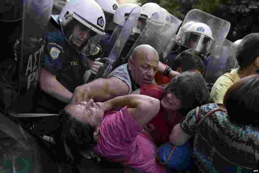 Những người lao công bị Bộ Tài chính sa thải đụng độ với cảnh sát chống bạo động trong một cuộc biểu tình phản đối bên ngoài Bộ Tài chính tại Athens, Hy Lạp.