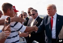 President Donald Trump greets supporters as he arrives on Air Force One at John Glenn Columbus International Airport in Columbus, Ohio, Aug. 4, 2018, en route to a rally at Olentangy Orange High School in Lewis Center, Ohio.