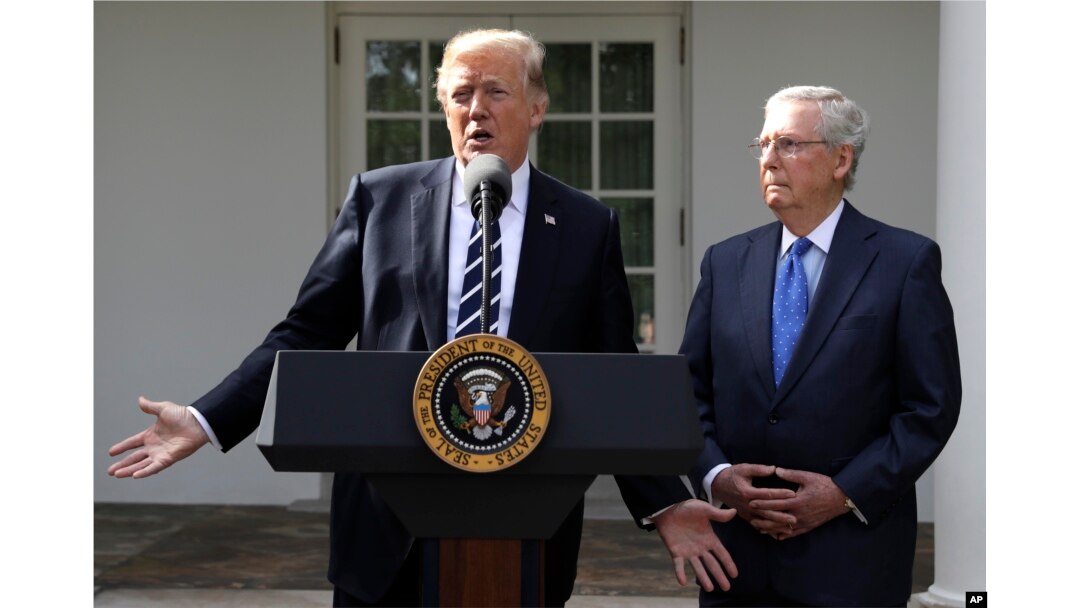 President Donald Trump answers questions with Senate Majority Leader Mitch McConnell, R-Ky., in the Rose Garden at the White House, Oct. 16, 2017.